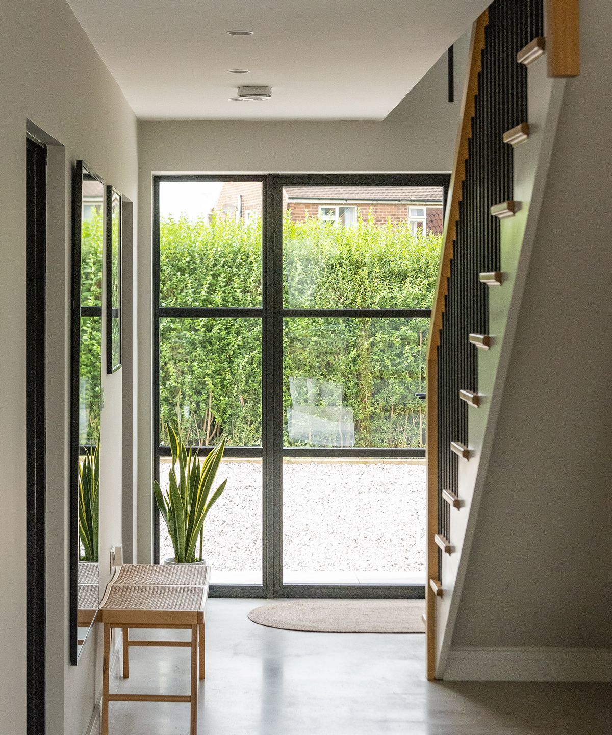 A light entranceway with a glass front door and polished concrete flooring