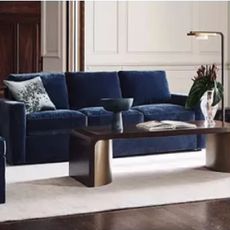 A living room with a blue sofa and metalic coffee table