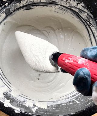 A bucket of mixed microcement for How to microcement kitchen cabinets a DIY process