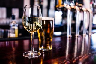A glass of wine and a glass of beer in a bar