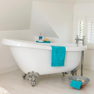 bathroom with white wall and bathtub with towel