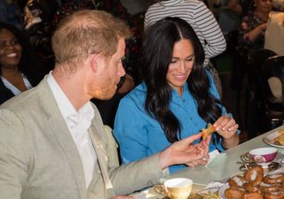 CAPE TOWN, SOUTH AFRICA - SEPTEMBER 23: Meghan, Duchess of Sussex and Prince Harry Duke of Sussex try some food as they visit the District 6 Museum and Homecoming Centre during their royal tour of South Africa on September 23, 2019 in Cape Town, South Africa. District 6 was a former inner-city residential area where different communities and races lived side by side, until 1966 when the Apartheid government declared the area whites-only and 60,000 residents were forcibly removed and relocated. (Photo by Samir Hussein/WireImage)