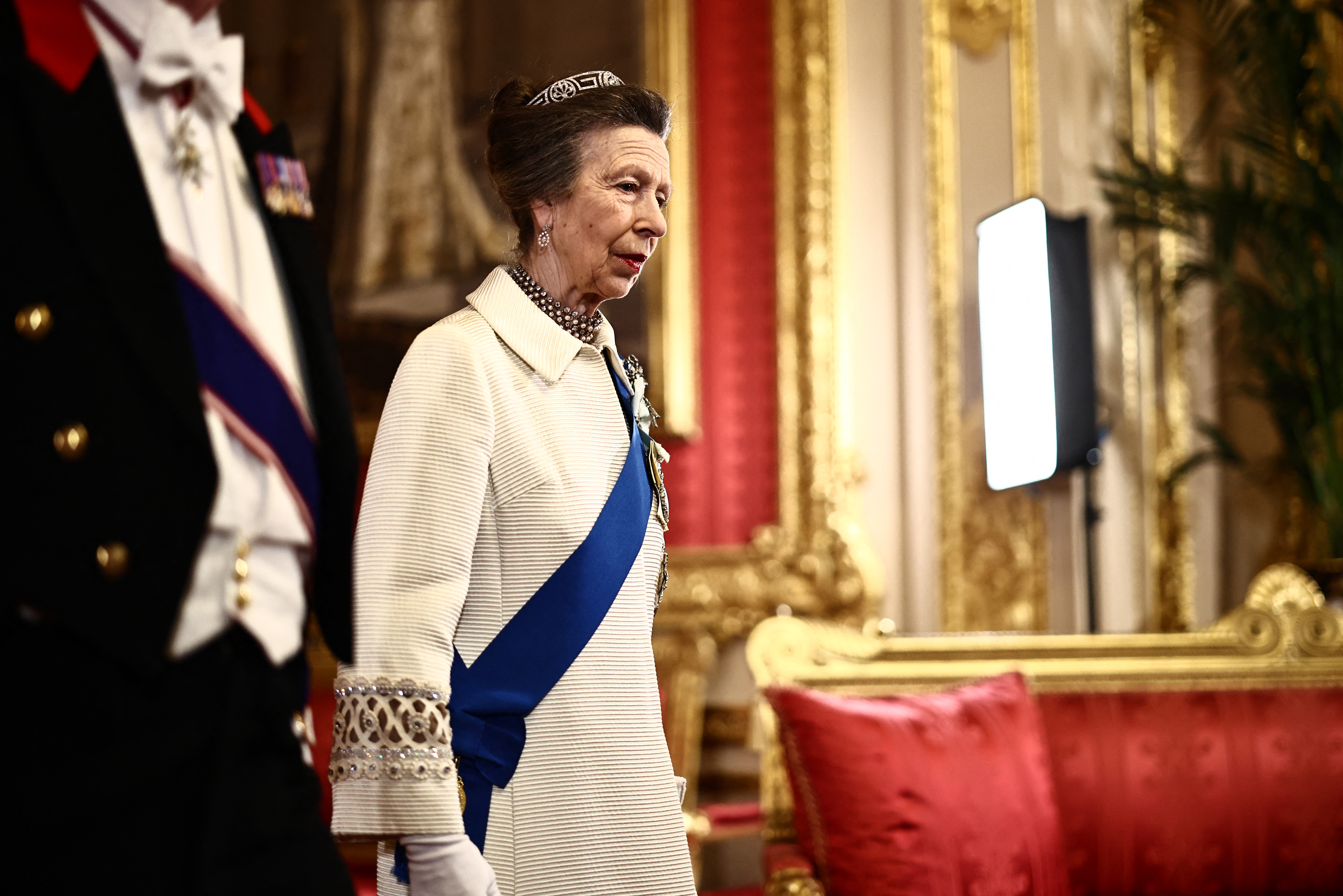 Princess Anne wearing a white coat and tiara