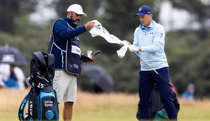 Michael Greller and Jordan Spieth wipe a golf club