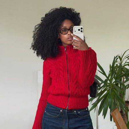 a woman wearing a red sweater and jeans