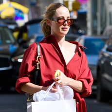 Jennifer Lawrence in NYC wearing a red oversized collared shirt with red pants, a black Dior Saddle bag, and orange slippers.