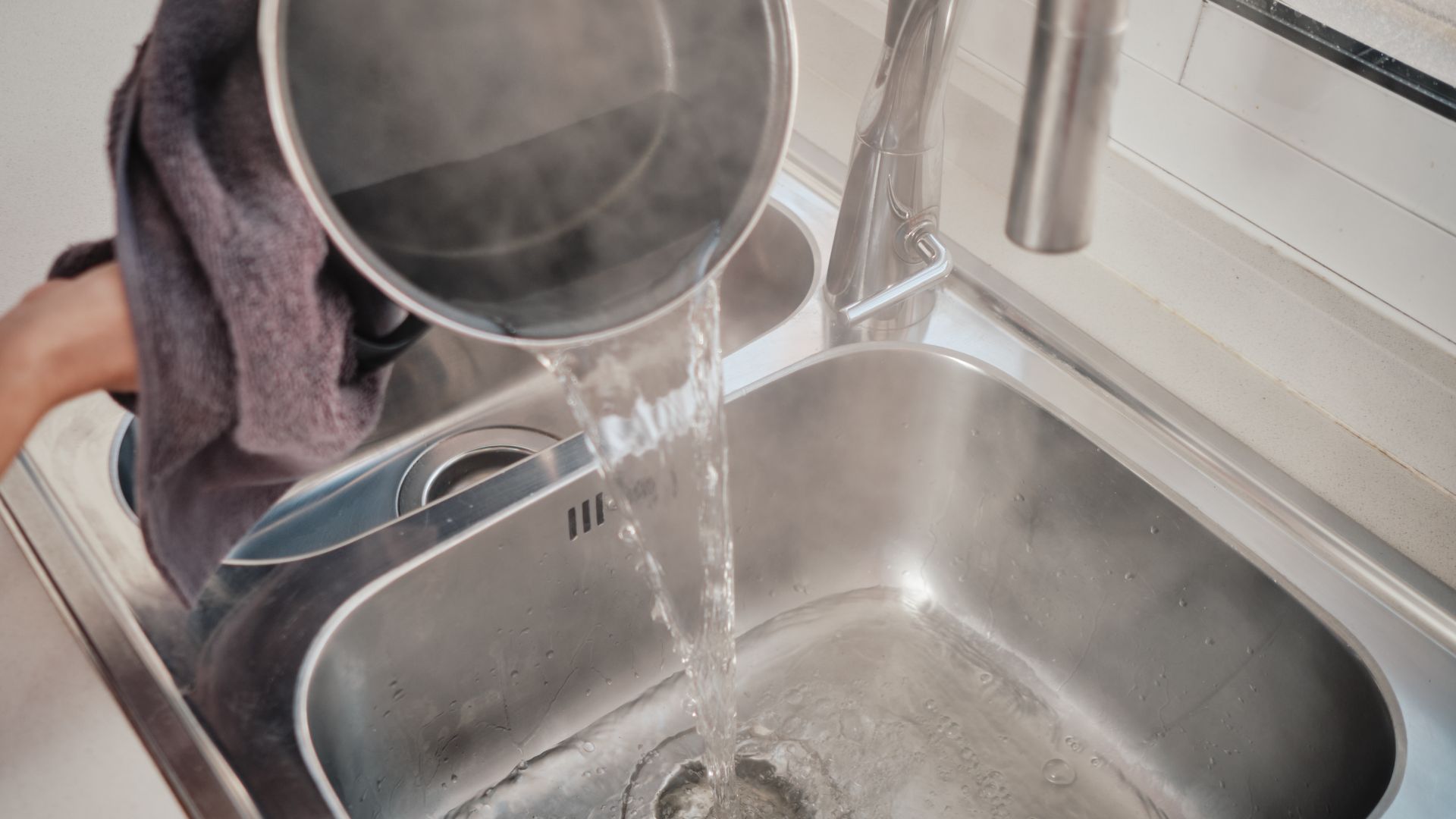 picture of person pouring boiling water down drain