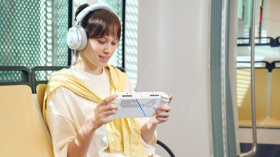 Woman wearing headphones and playing on the Asus ROG Xbox Ally while riding a train