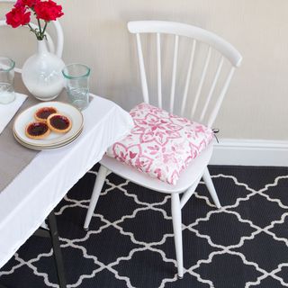 room with pattern carpet and dinner table and white chair