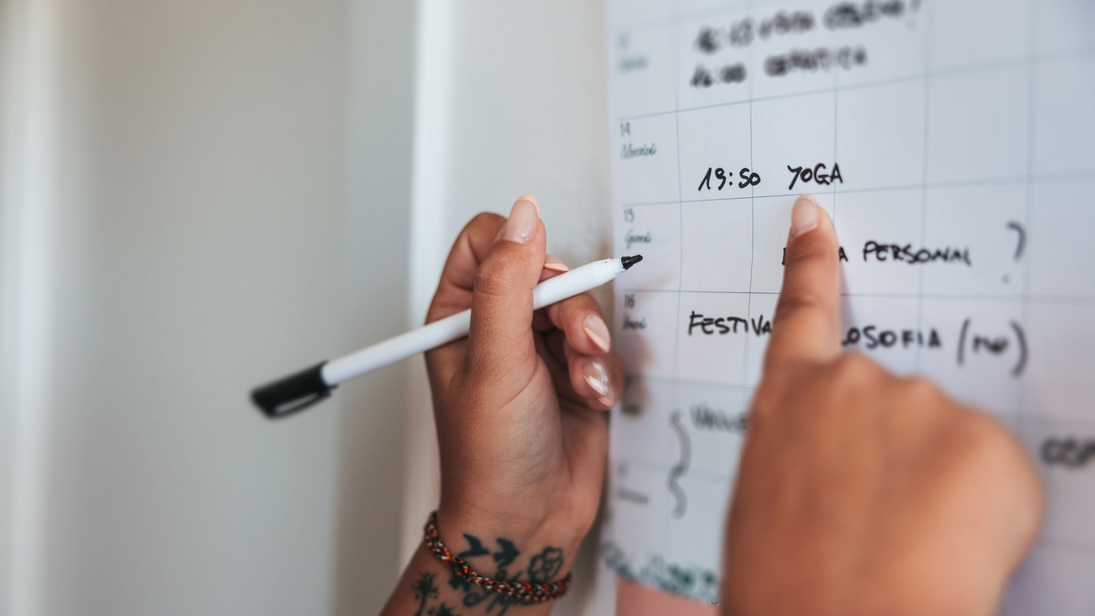 A close-up picture of someone's hands pointing at a calendar
