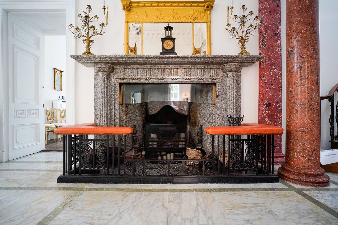 A large fireplace with ornate seating around it