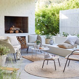 outdoor sitting area with white sofa and fire place