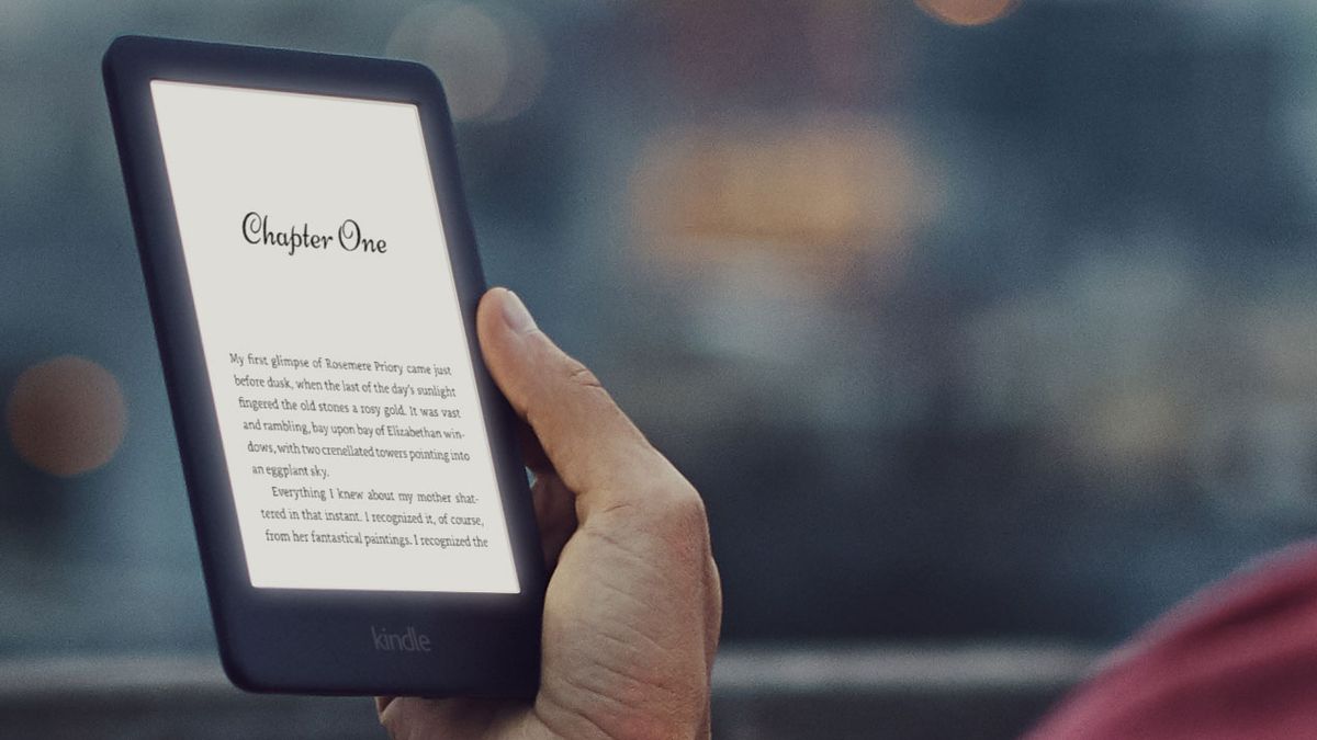 Press photo of a hand holding an Amazon Kindle