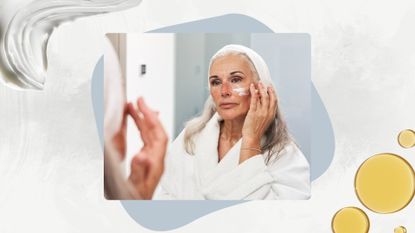 Image of woman with long silver hair wearing a white dressing gown and headband, applying moisturiser on her face whilst looking in the mirror, on a white marble background with a cream and oil swatch