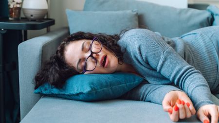 Fully dressed woman sleeping on the sofa