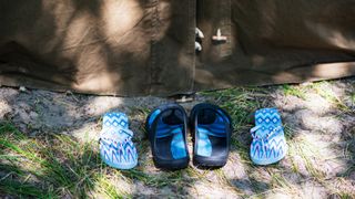 Pairs of flip flops outside tent