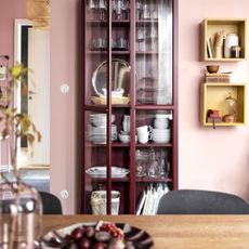 kitchen with shelves with glass door and pink wall