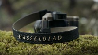 The Hasselblad X2D 100C Earth Explorer Edition camera and lens sitting on a mossy, rocky outcrop