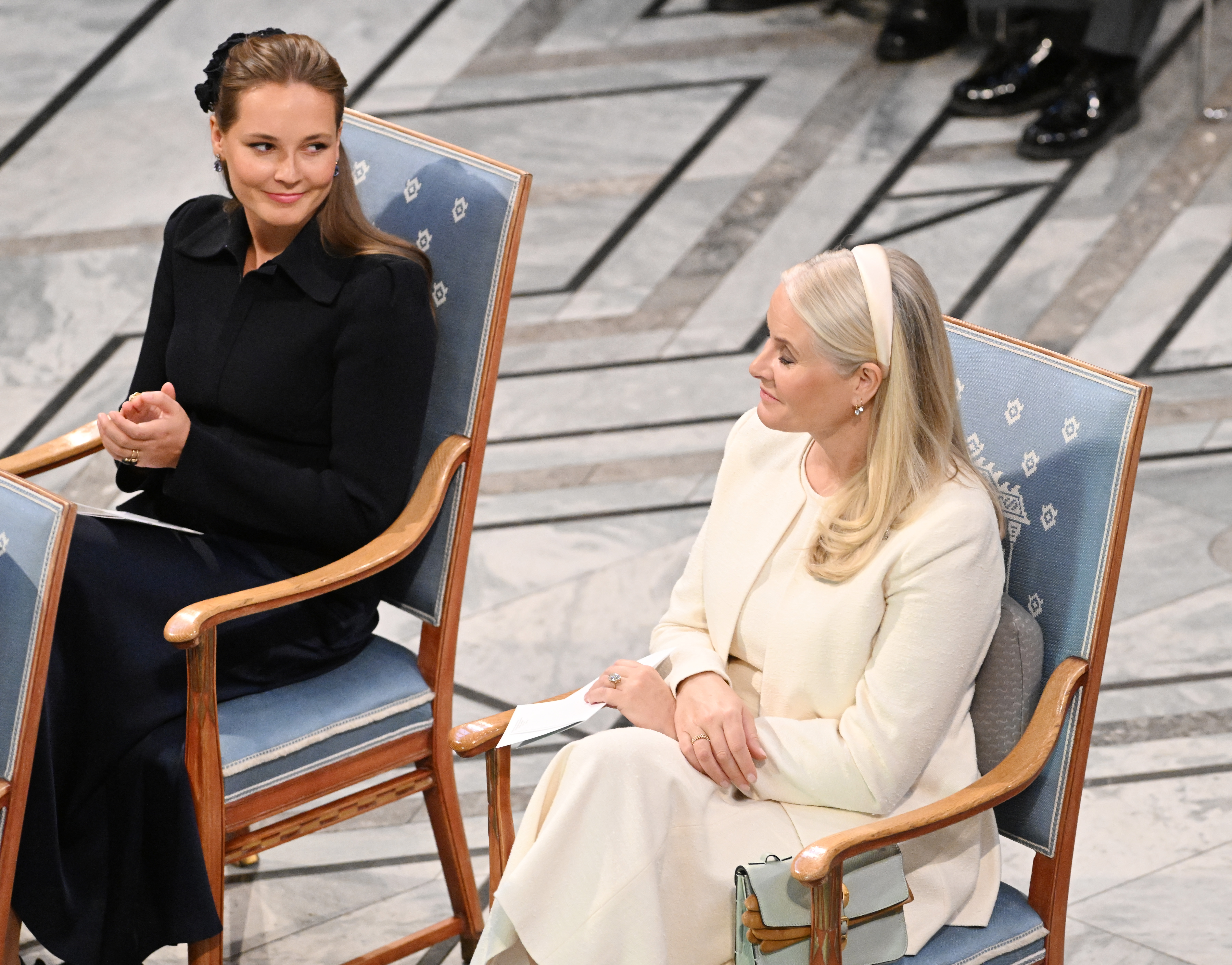 Princess Ingrid Alexandra sitting next to Crown Princess Mette-Marit