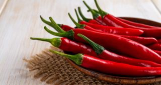 Collection of chili peppers in a wooden bowl