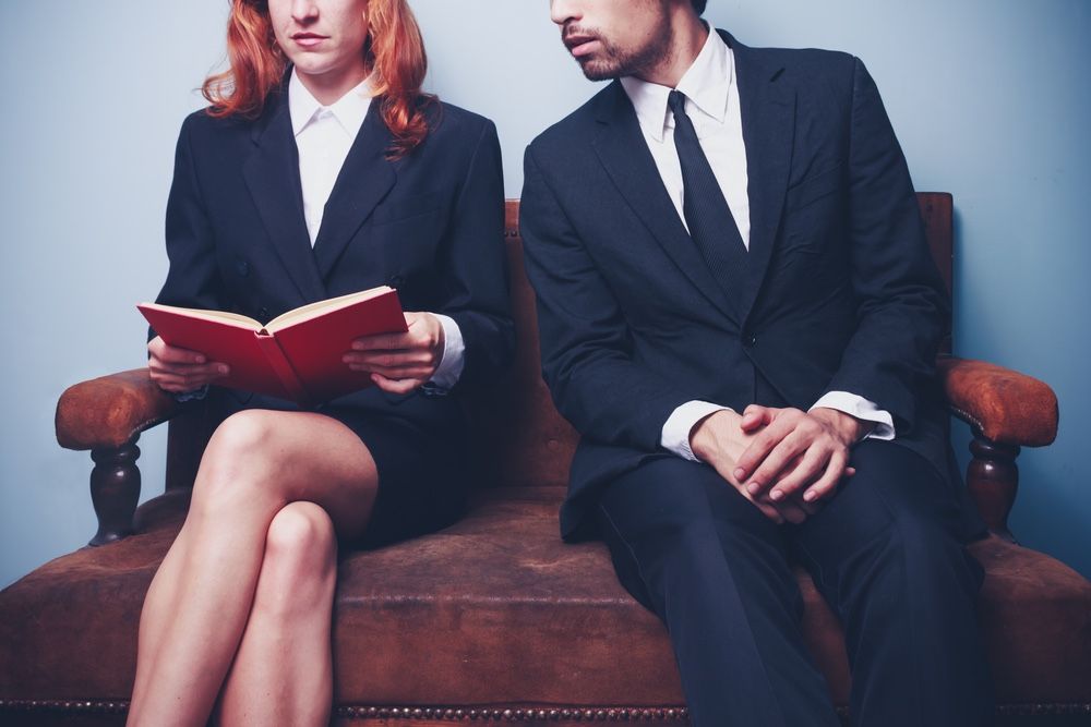 businessman looking at woman&#039;s book.