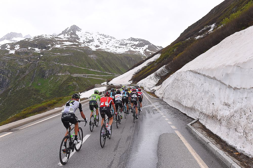 The peloton climb aling snow-lined roads during stage 5 at the Tour de Suisse