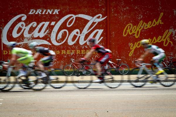 Riders pass by an old Coke sign at the US Pro Cycling Championships in Greenville, SC.