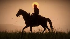 Red Dead Redemption 2 screenshot showing the silhouette of a man with a cowboy hat on horseback, a glowing sun seen behind him