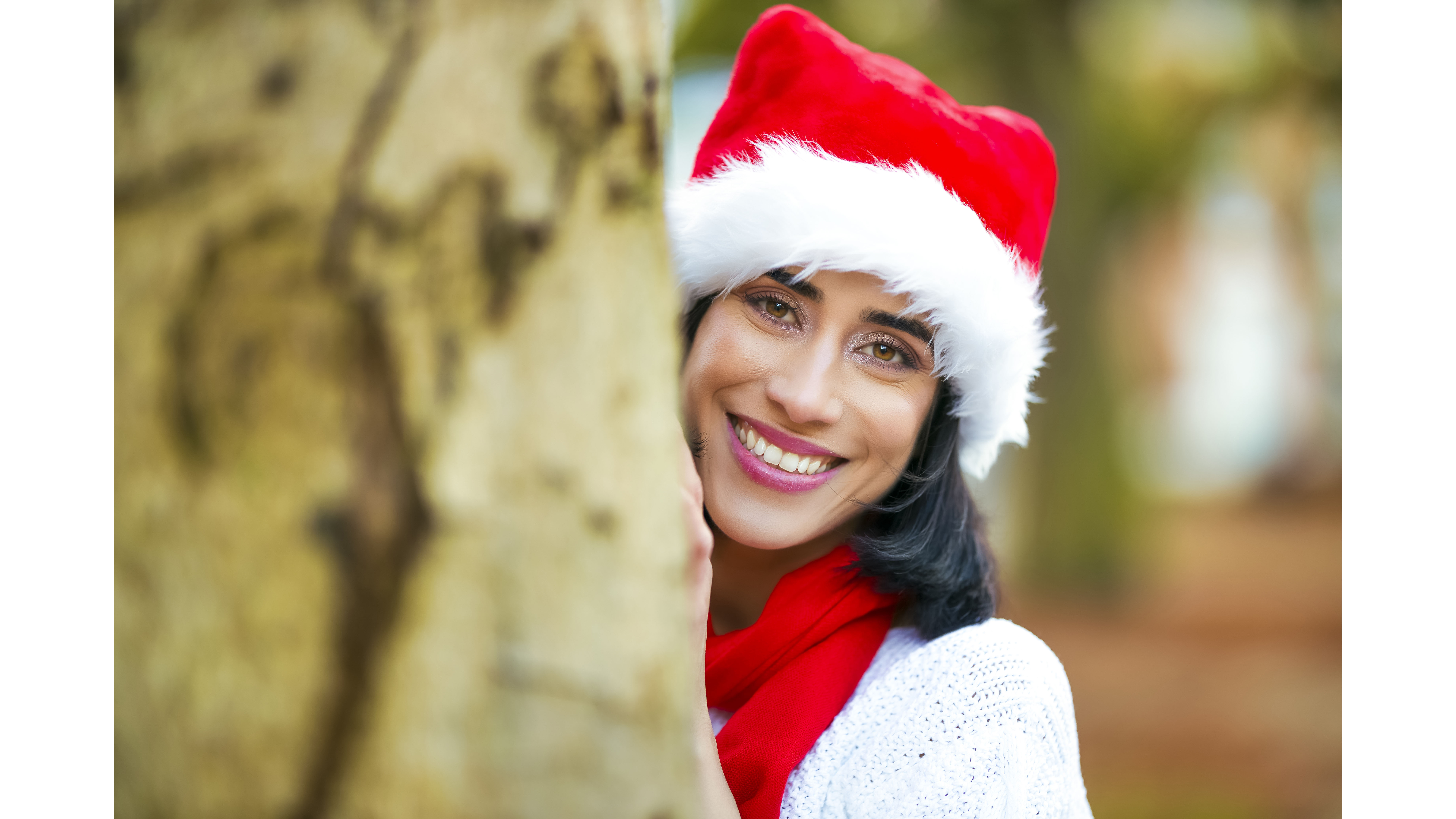 A model dressed as Santa Claus smiles