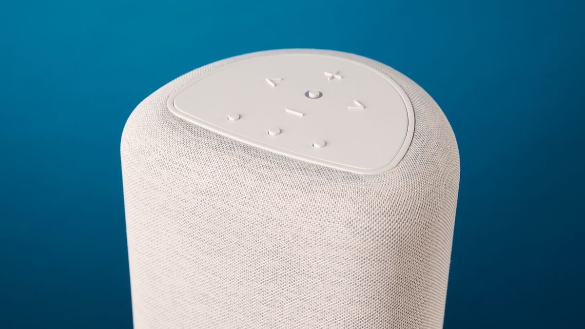 the bluesound pulse flex wi-fi speaker in pale gray photographed against the blue tom's guide background