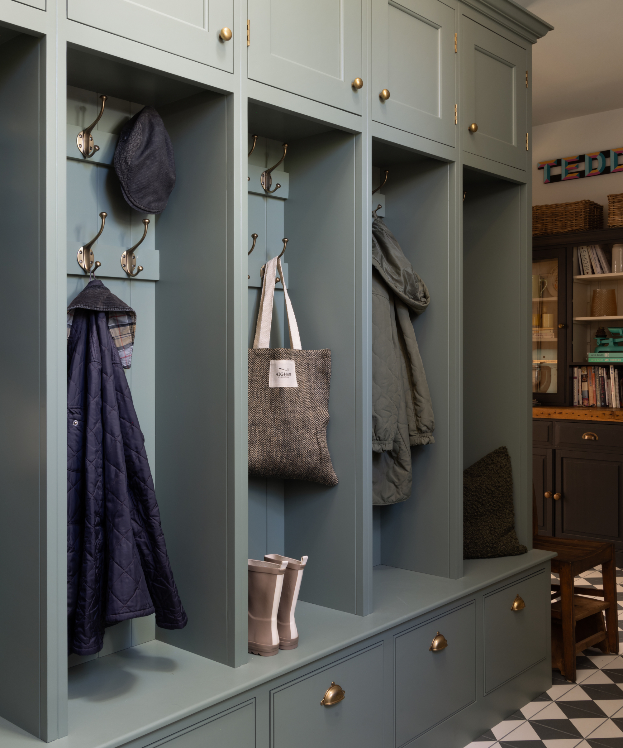 boot room storage divided into individual sections with each having its own set of hooks, drawer and cupboard above