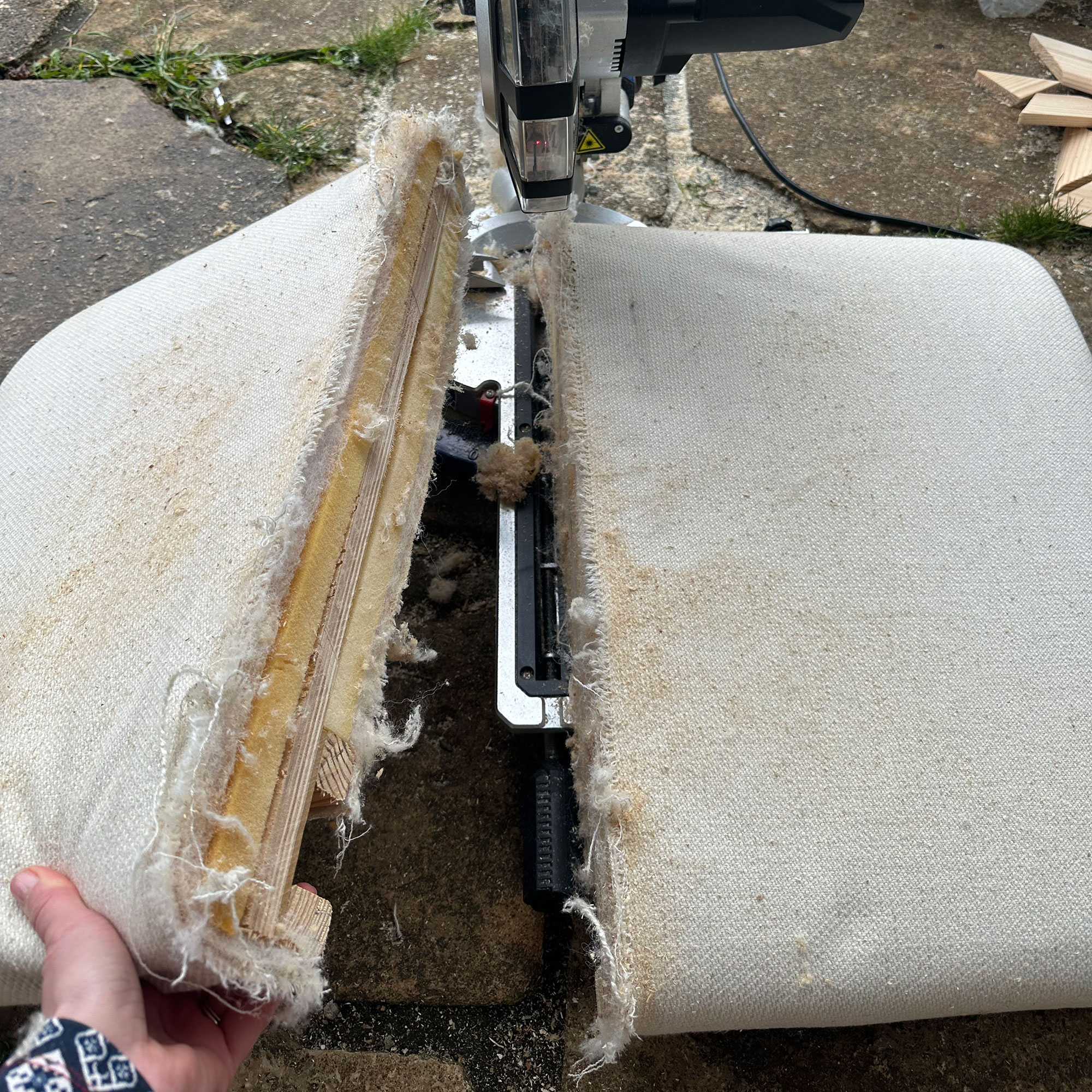 Sofa cushions being cut in half by saw