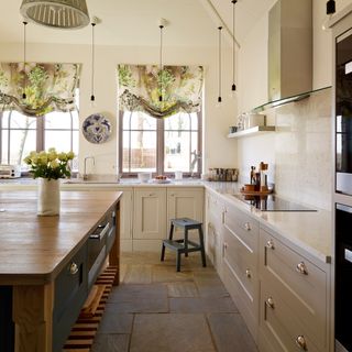 Cream kitchen with stone floor and wooden island