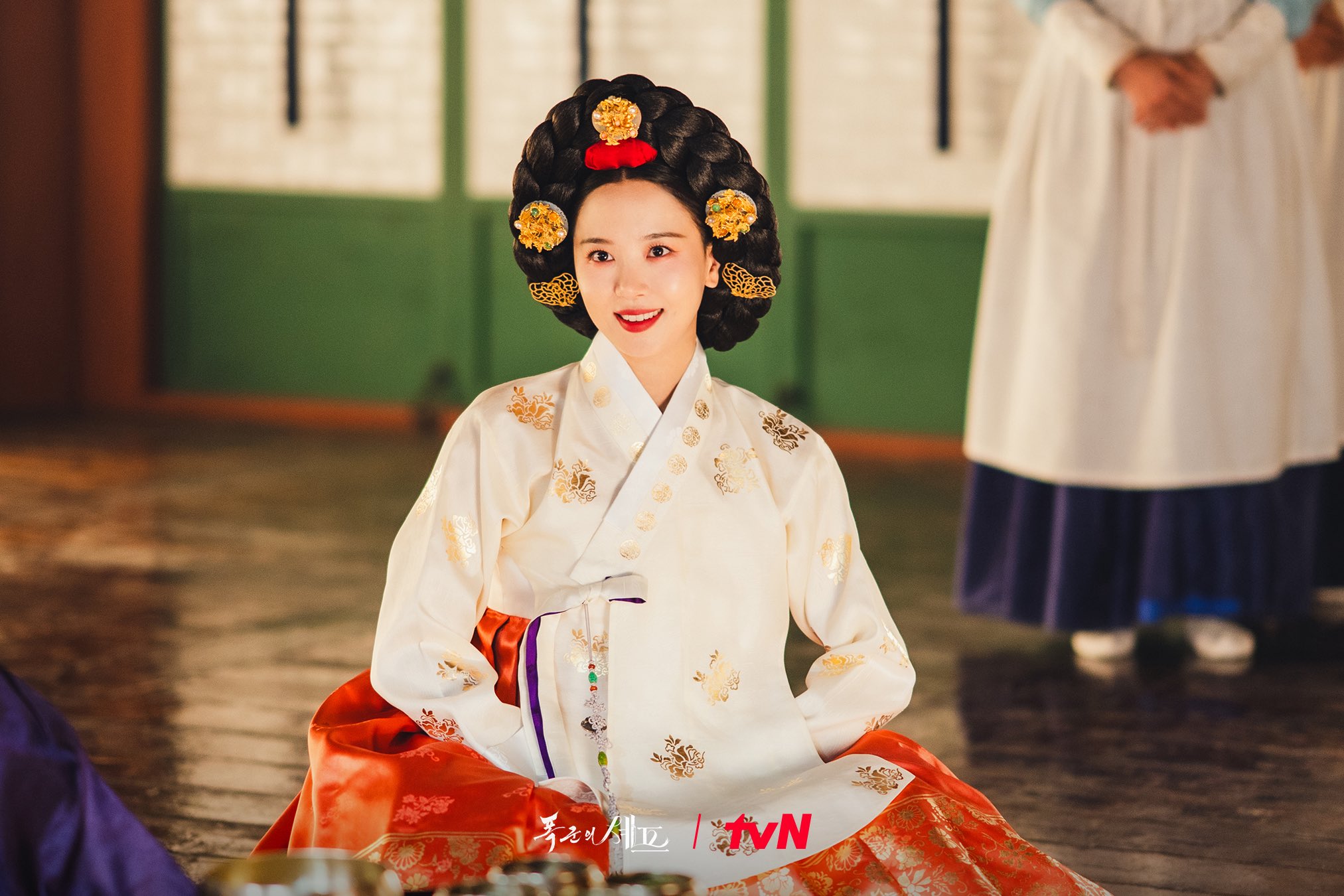 A woman (Kang Han-na) sits on the floor wearing a Joseon-era noblewoman outfit, in &#039;Bon Appetit, Your Majesty.&#039;