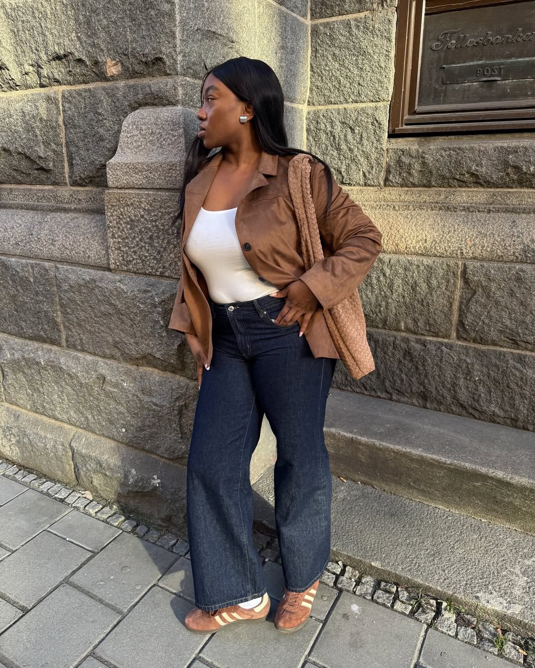 @nnennaechem wearing flared jeans, t-shirt and trainers