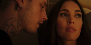 Machine Gun Kelly stands close to Megan Fox in a scene from 'Midnight in the Switchgrass'