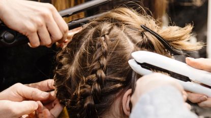 a woman having her hair done - how to clean hair straighteners
