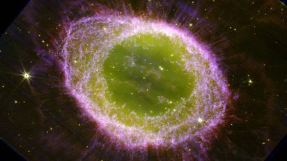 Imagine taken by the James Webb Space Telescope of the Ring Nebula (Messier 57). It looks like a glowing green eye surrounded by purple gas.
