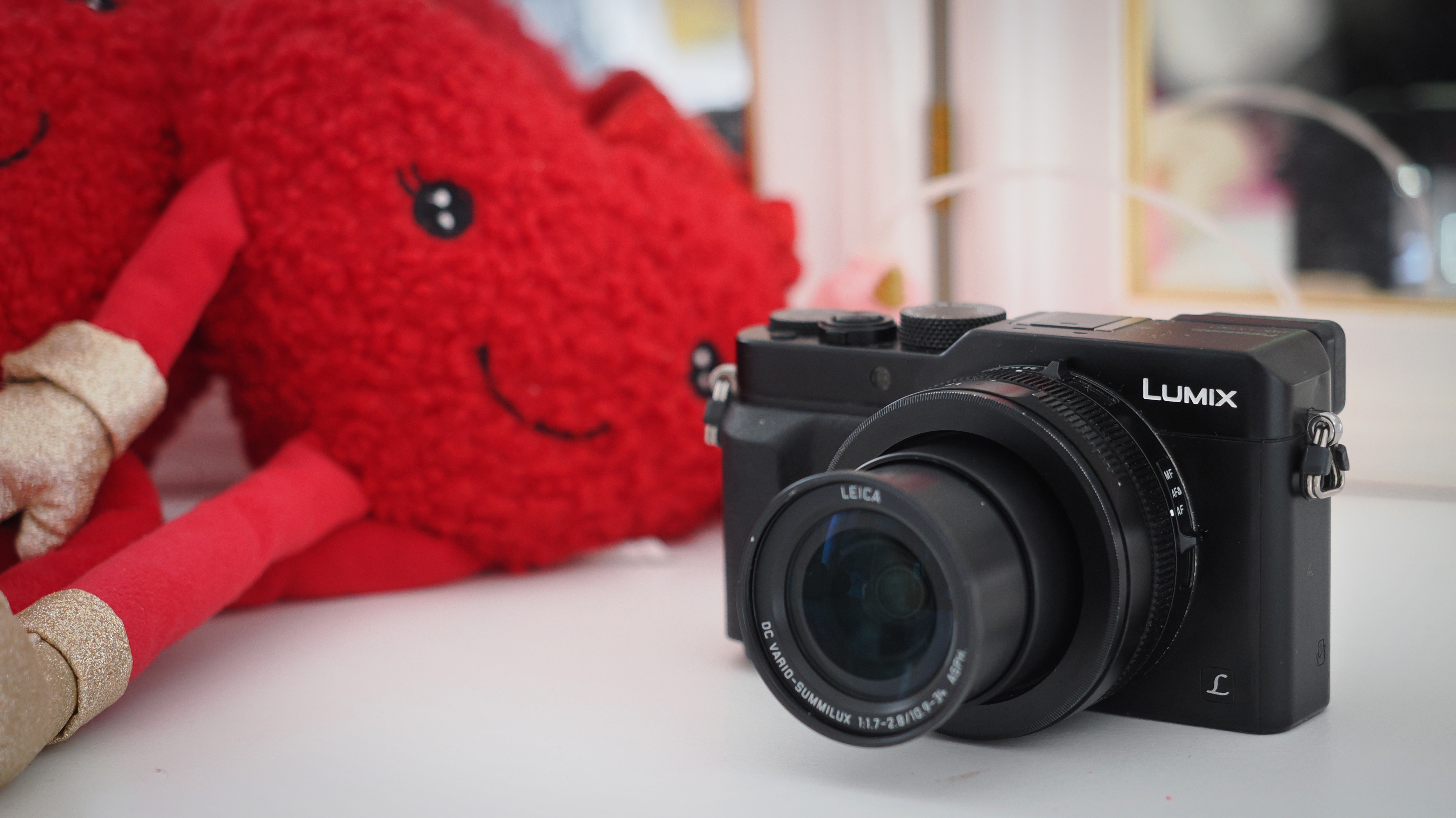 Panasonic Lumix LX100 on a table in front of plush toys