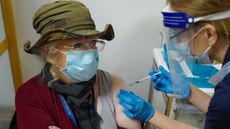 An NHS nurse vaccinates a patient