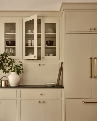 A kitchen with beige cabinets and unlacquered knobs