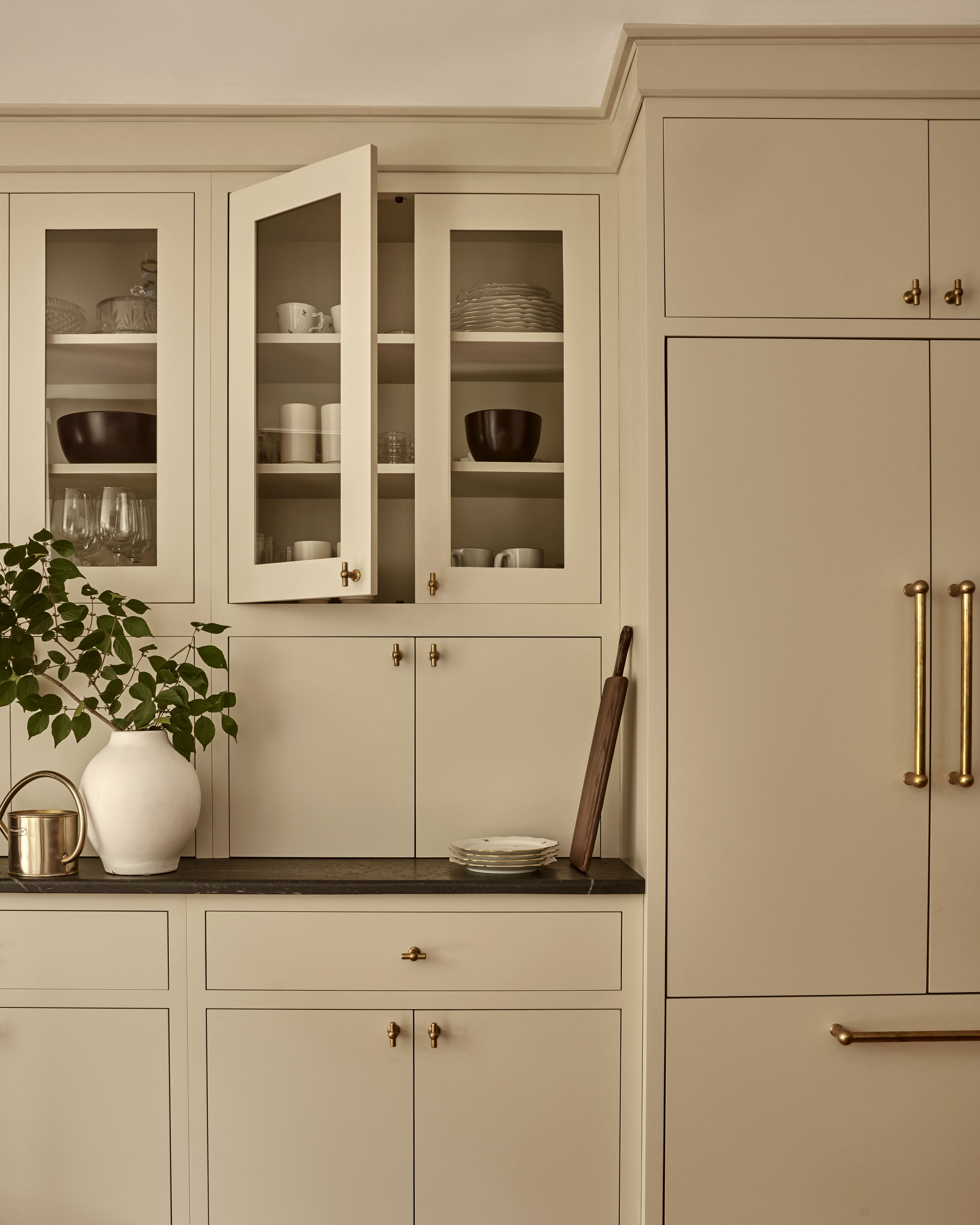 A kitchen with beige cabinets and unlacquered knobs