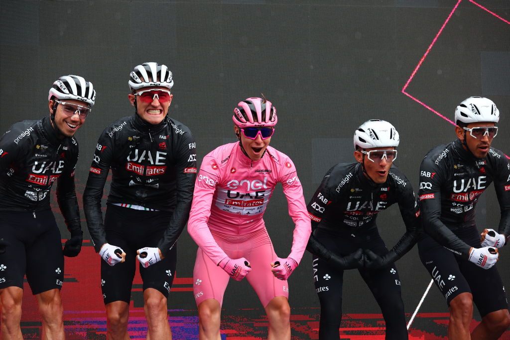 Team UAE's Slovenian rider Tadej Pogacar wearing the overall leader's pink jersey pose on the podium flanked by his teammates before the start of the 20th stage of the 107th Giro d'Italia cycling race, 184km between Alpago and Bassano del Grappa on May 25, 2024. (Photo by Luca Bettini / AFP)