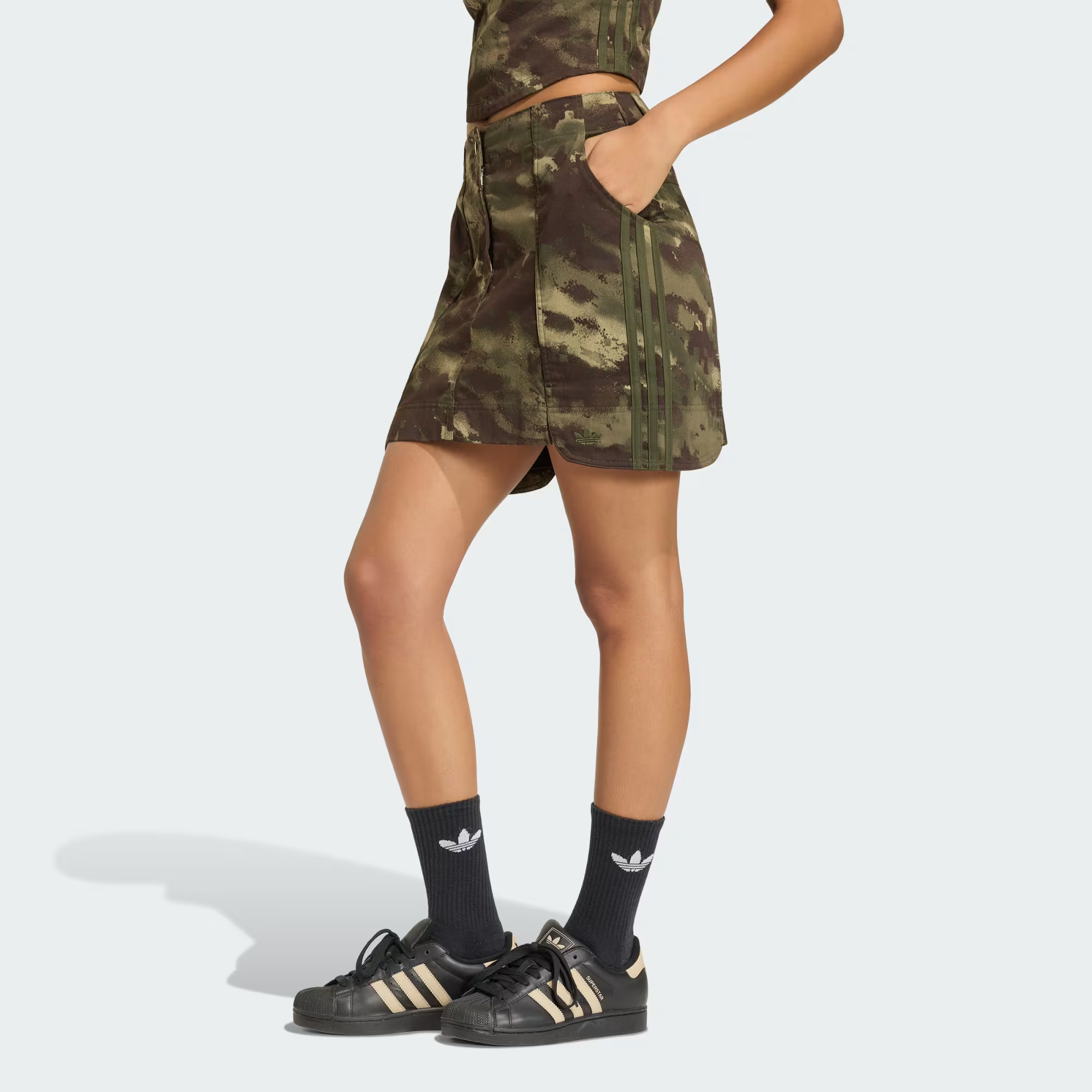 A woman wearing an Adidas camouflage mini skirt.