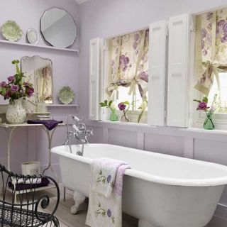 bathroom with lilac walls floral curtains and vintage mirrors