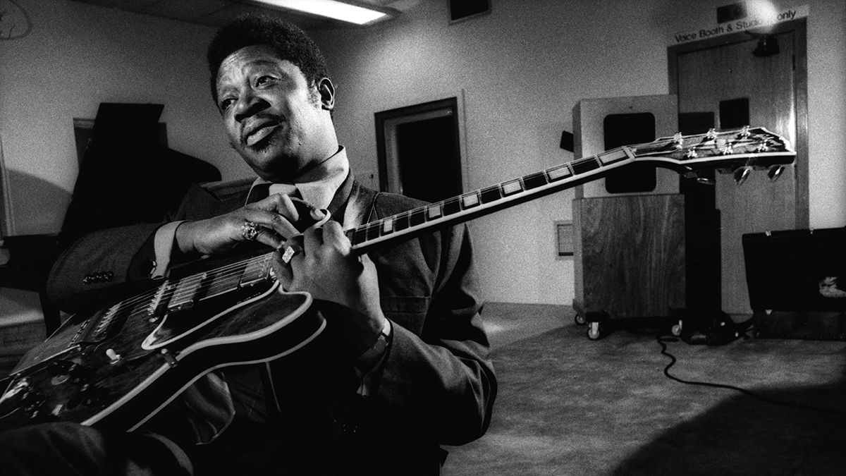 Black and white photo of BB King sat down holding his Gibson guitar