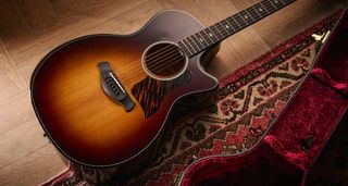 Taylor Builder’s Edition 514ce Kona Burst pictured against a wooden floor and patterned rug.