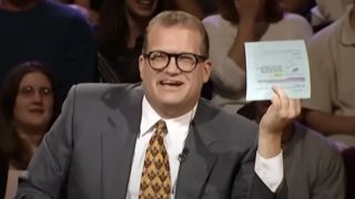 Drew Carey holding up a card on Whose Line Is It Anyway?