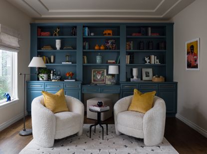 a blue living room with white chairs