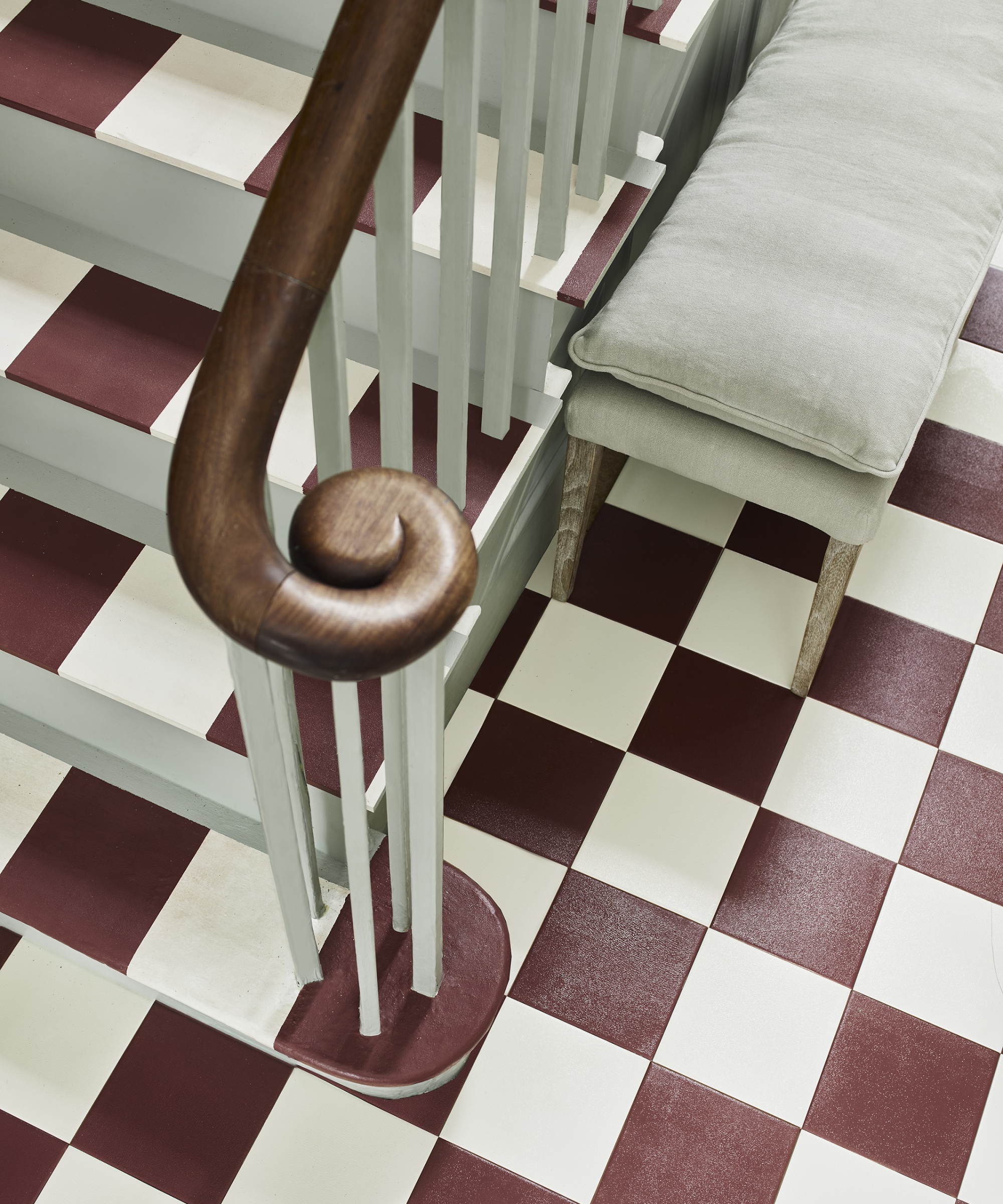hallway floor and painted stairs with white and red chequerboard patter and green treads and spindles